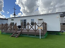 Una casa móvil blanca con una terraza marrón y un cartel que indica Montana.