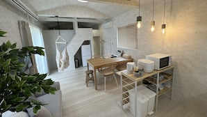 A modern kitchen with a wooden table, hanging light fixtures, and a built-in microwave. - SolanaFujiyamanakako (Yamanakako)