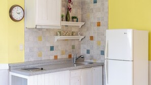 A kitchen with a white refrigerator, a sink, and a clock on the wall. - Ganghwa Sky Garden Poolvilla (Incheon)