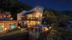 A multi-story residential building with a balcony, a swimming pool, and a garden. - Ganghwa Sky Garden Poolvilla (Incheon)