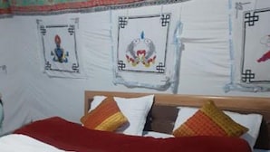 A bed with a red and white bedspread, a wooden headboard, and multiple pillows. - Martsemik Camping Spangmik (Leh)