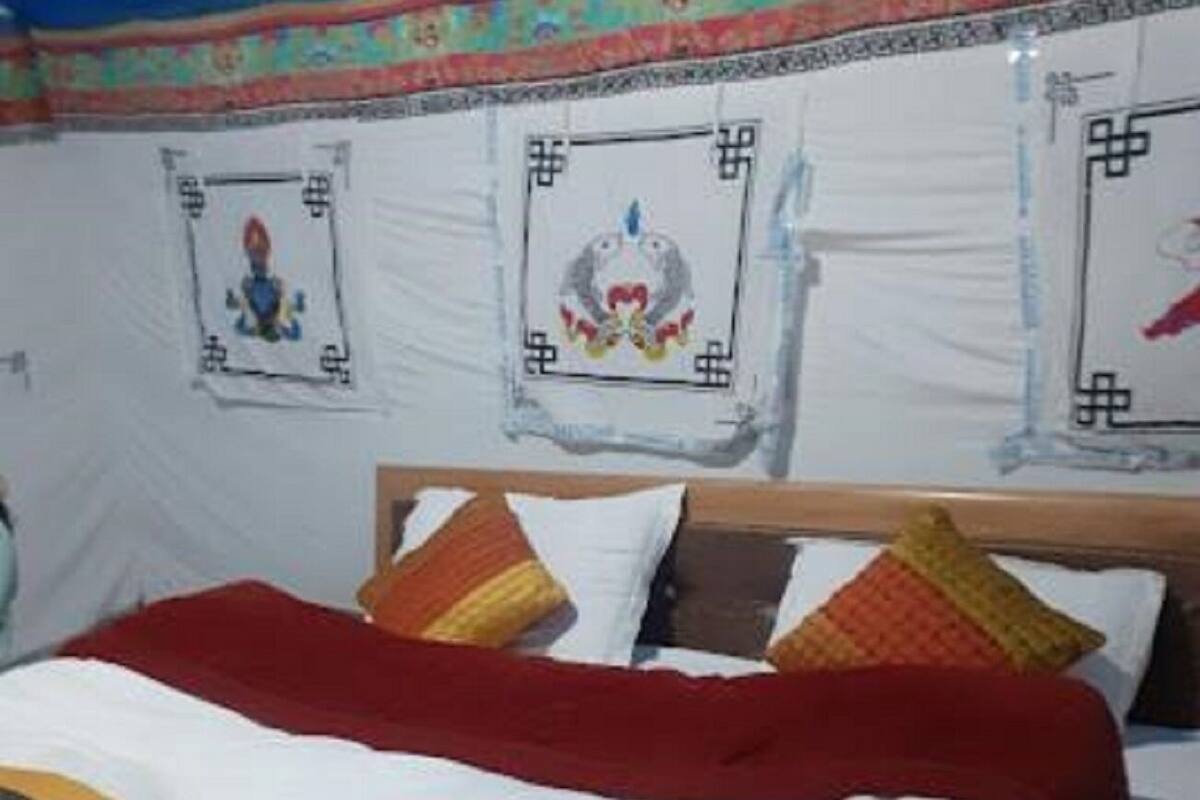A bed with a red and white bedspread, a wooden headboard, and multiple pillows.