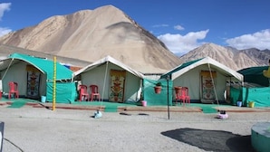 A row of tents with red chairs in front, set against a mountainous backdrop. - Martsemik Camping Spangmik (Leh)
