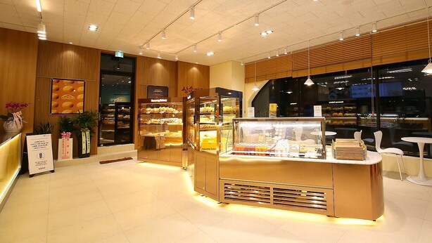 A bakery with a modern interior, featuring display cases and a counter with pastries. - MGM Hotel (Gangneung)