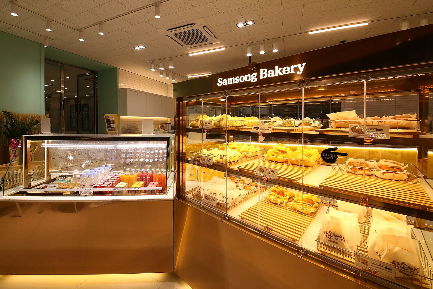 A bakery display with various baked goods and beverages.