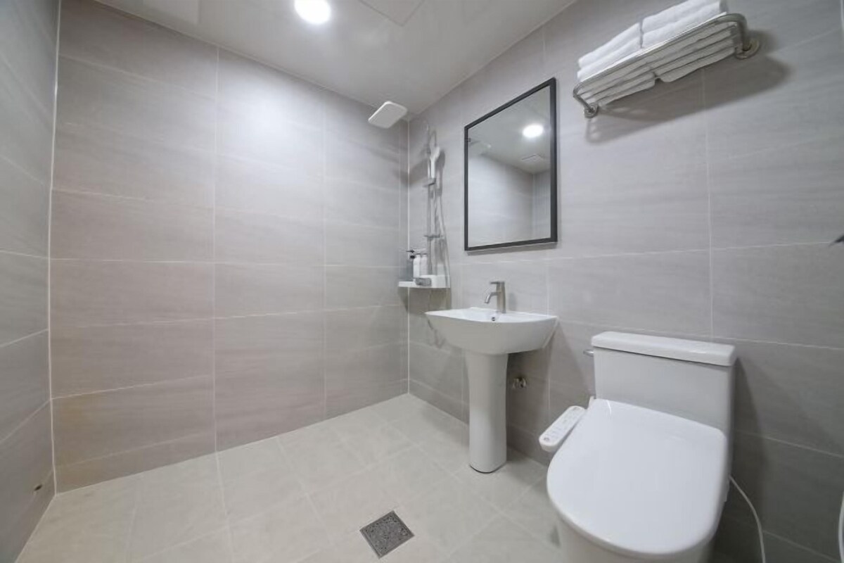 A modern bathroom with a toilet, sink, and shower.