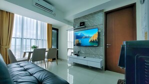 Uma sala de estar moderna com uma televisão de tela plana fixada em uma parede de mármore, um sofá, uma área de jantar com cadeiras e uma porta.