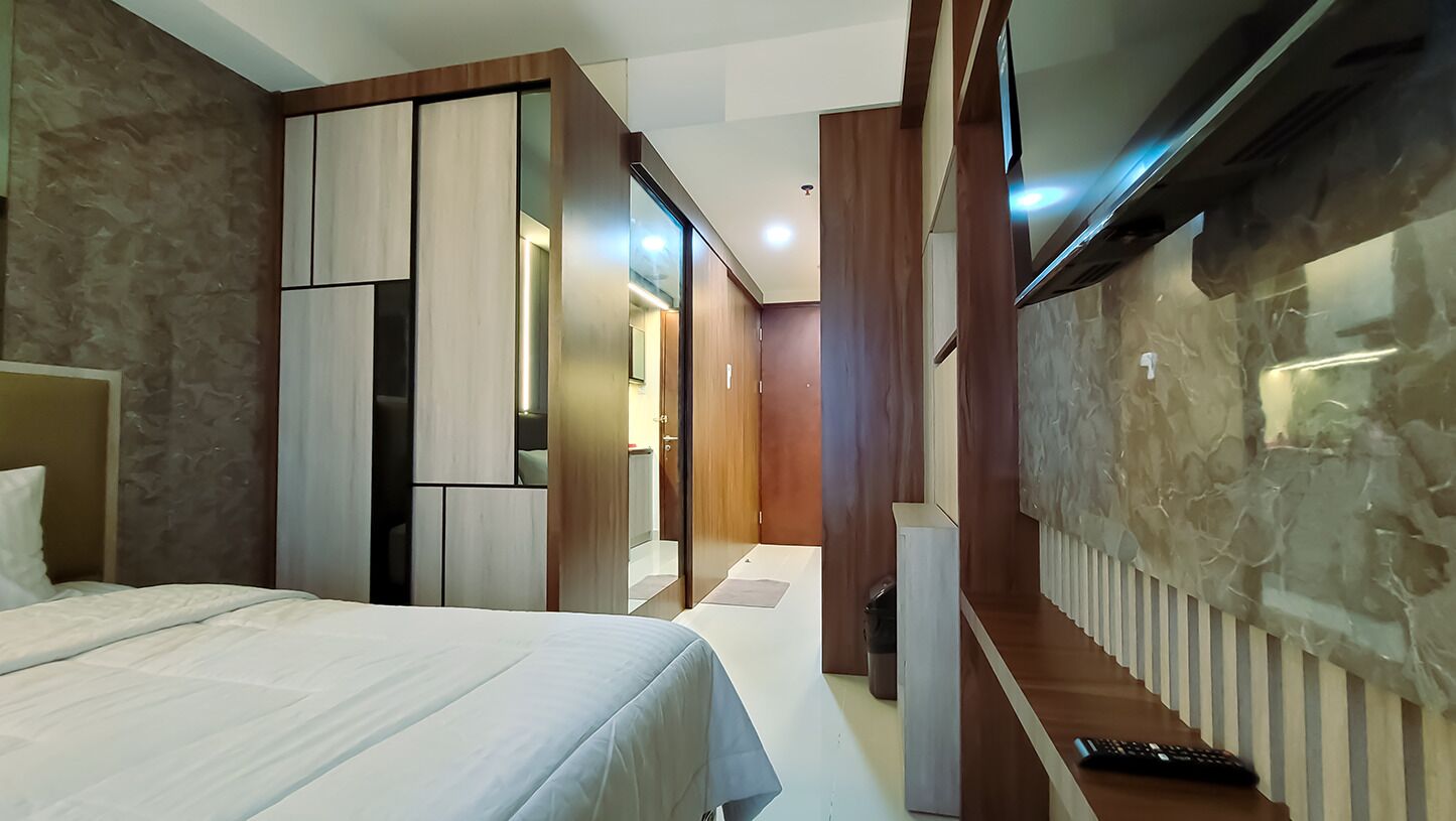 Una habitación de hotel moderna con una cama, un escritorio y una televisión.