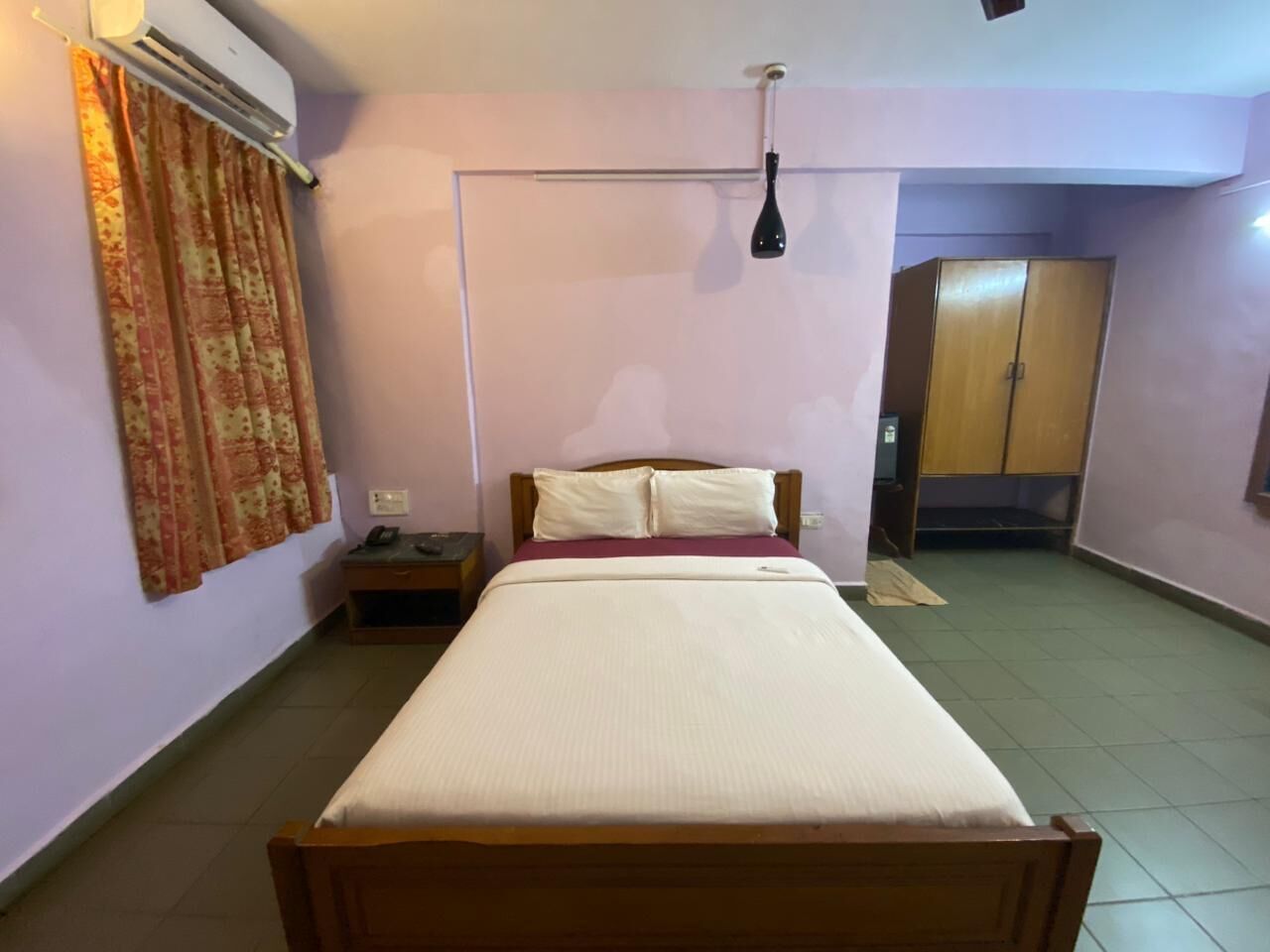 A bedroom with a bed, a nightstand, a wardrobe, and a ceiling fan.