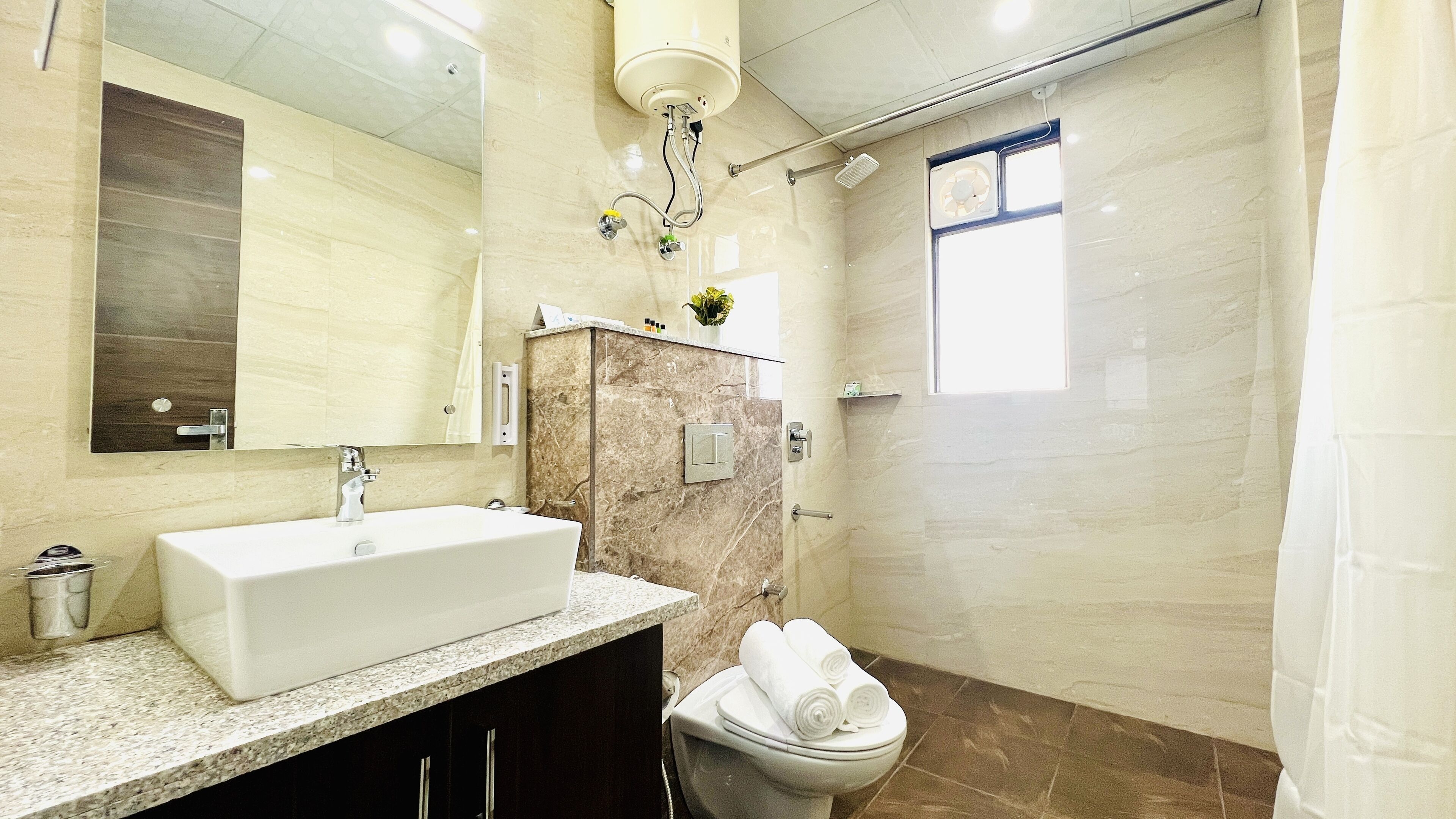 A modern bathroom with a large sink, a toilet, and a shower area.