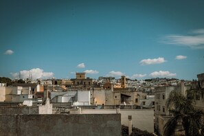 A densely packed urban area with various buildings, including a prominent tower and several smaller structures. - Palazzo Piccinno (Parabita)