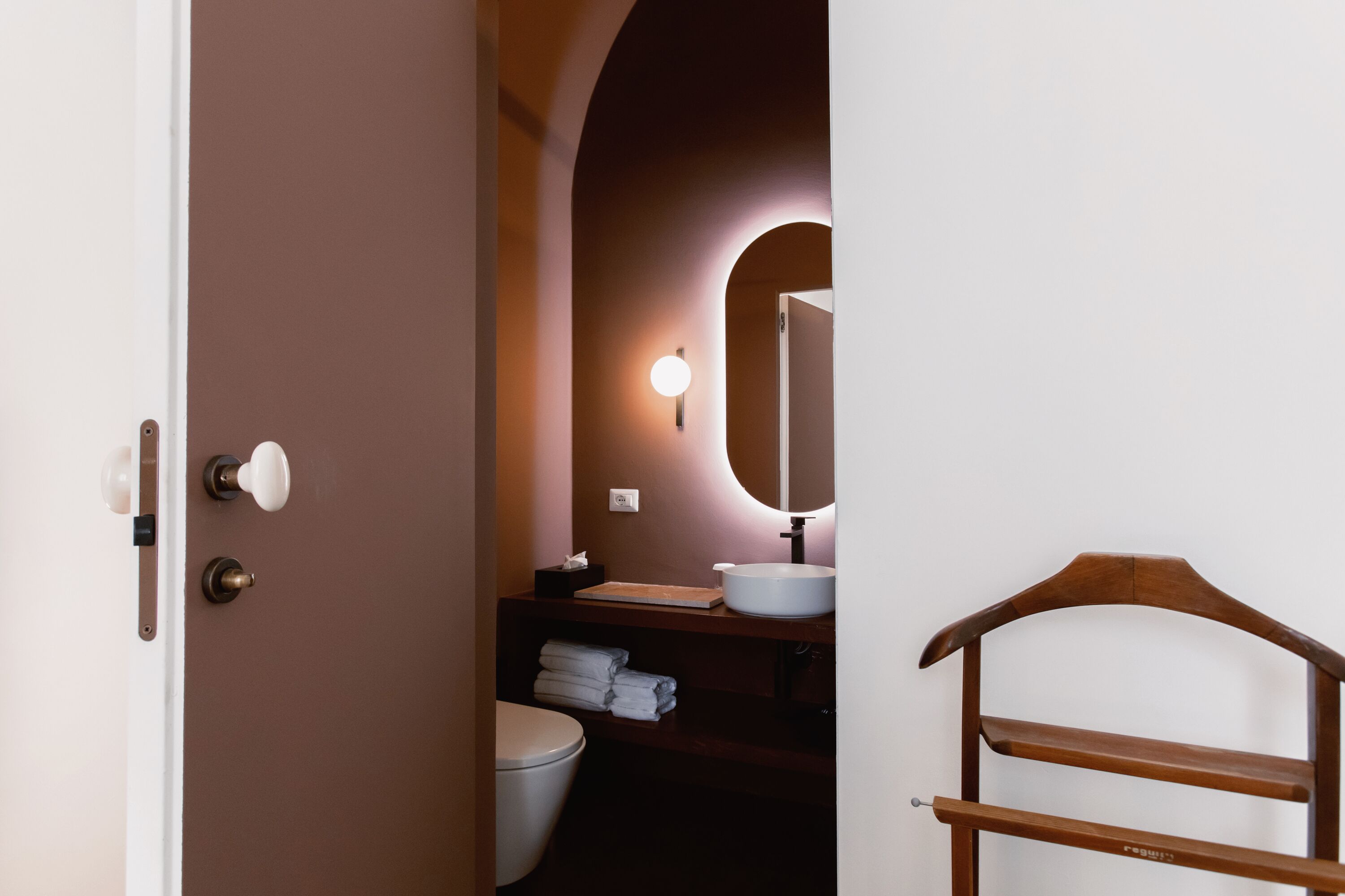 Une salle de bain avec un meuble-lavabo en bois, un lavabo blanc et un miroir.
