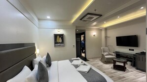Een moderne hotelkamer met een groot bed, een flatscreen televisie, een bureau en een stoel.