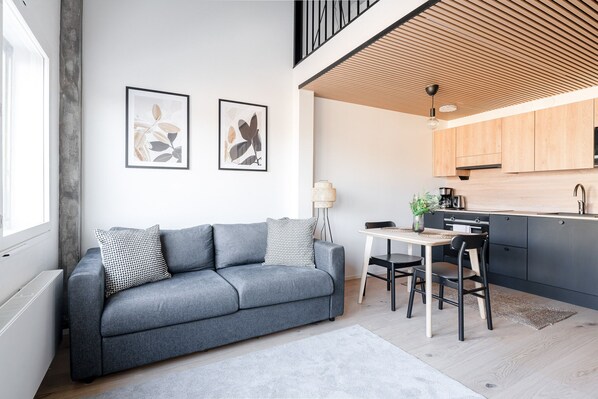 Relax in this stylish living space with a sofa, dining area, and kitchen.