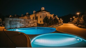 A swimming pool area with a stone wall and a building in the background. - Safari Relaks i Aktywny Wypoczynek Idealna Lokalizacja (Trzebiatow)