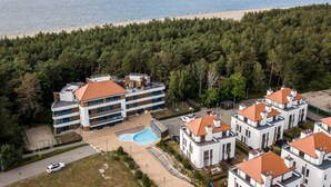 A coastal hotel with multiple buildings, a swimming pool, and a beach view. - Safari Relaks i Aktywny Wypoczynek Idealna Lokalizacja (Trzebiatow)