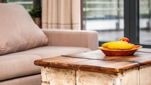 A modern living room with a beige sofa, a wooden coffee table, and a bowl of fruit. - Marina Dwupoziomowy Apartament Przy pla y Baltica Heaven (Trzebiatow)
