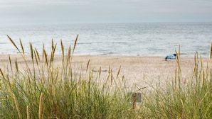 A beach with tall grass in the foreground and a calm sea in the background. - Marina Dwupoziomowy Apartament Przy pla y Baltica Heaven (Trzebiatow)