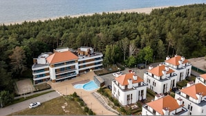 Un hotel de varios pisos con piscina y vista a la playa.