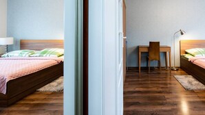 A bedroom with two beds, a desk, and a chair. - Santo Relaks nad Morzem Blisko Centrum i Parku (Kolobrzeg)