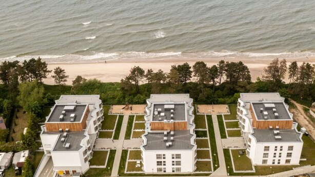 A modern hotel complex with multiple buildings, a beach view, and a landscaped garden area. - Hermoso Wypoczynek w Strefie SPA Blisko Morza (Mielno)
