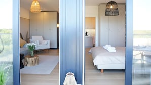 A modern bedroom with a bed, bedside table, and a hanging light fixture. - View Luksusowy Apartament SPA Ko Obrzeg Polanki Aqua (Kołobrzeg)