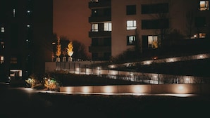Ein Nachtblick auf ein modernes Gebäude mit beleuchteten Fenstern und einem gut ausgeleuchteten Weg.