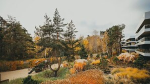 Een woonwijk met moderne gebouwen, een speeltuin en herfstkleurige begroeiing.