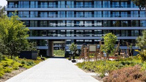 A modern building with multiple floors, large windows, and a central entrance. - Art Forrest 33 K in Rogowo (Trzebiatow)