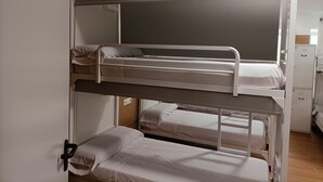 A bunk bed room with three levels, each with a mattress and pillows. - ALBERGUE VALIN LAMA (Palas de Rei)