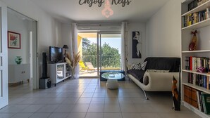 En moderne stue med fjernsyn, sofa, sofabord og bogreol.