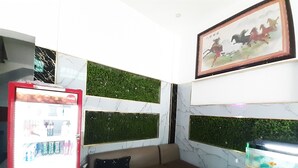 A room with a sofa, a fish tank, and a wall with green panels. - Tam My Hotel (Ho Chi Minh City)
