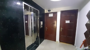 A room with a large mirror, two wooden doors, and a ceiling light. - Tam My Hotel (Ho Chi Minh City)