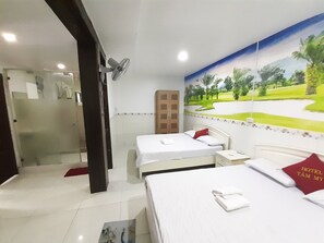 A hotel room with a bed, a nightstand, a desk, a chair, a shower area, and a mural on the wall. - Tam My Hotel (Ho Chi Minh City)