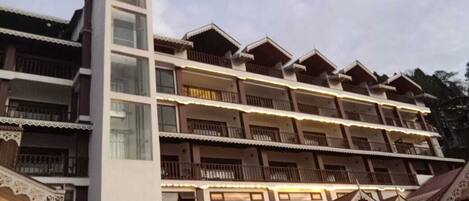 Un hotel de varios pisos con balcones y una estructura imponente en forma de torre.