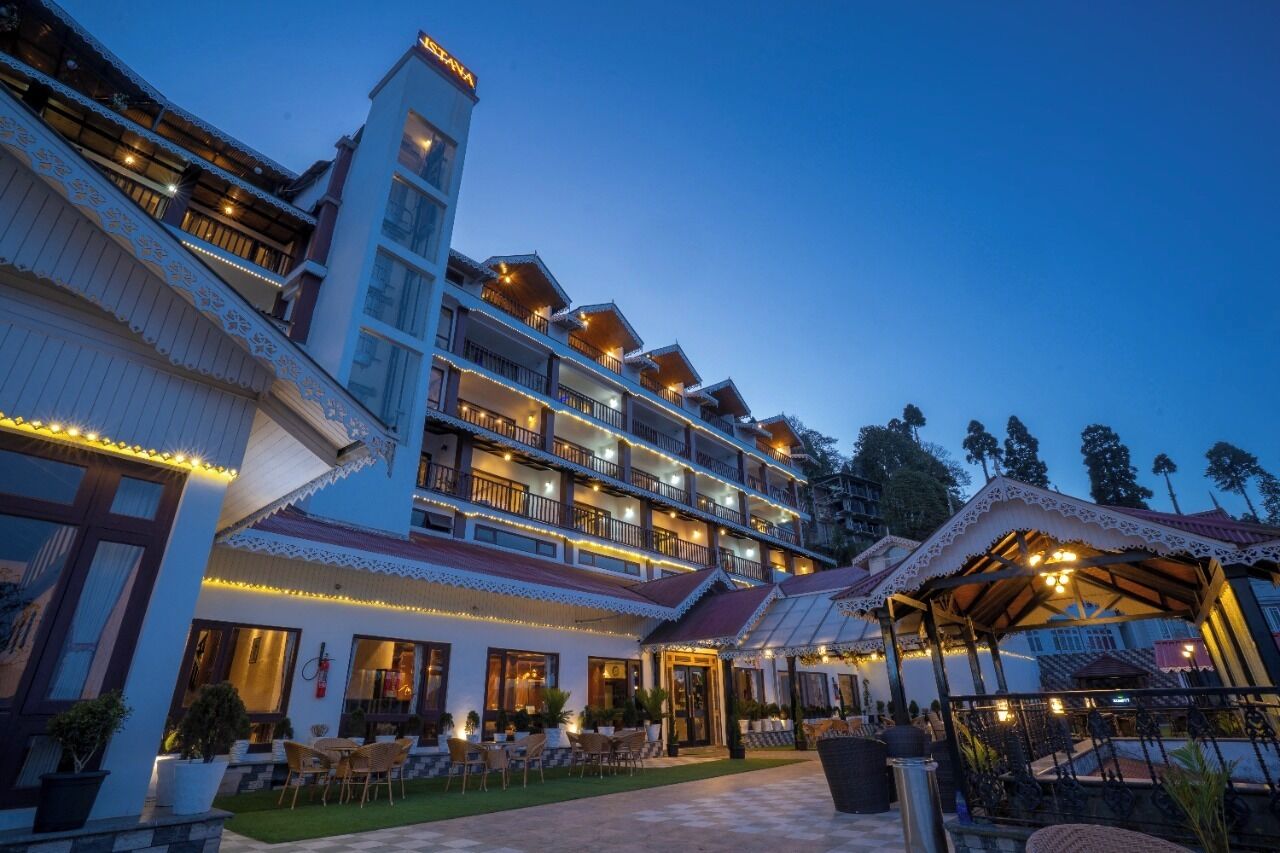 A multi-story hotel with balconies, outdoor seating, and a covered patio area.