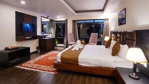 Une chambre d’hôtel moderne dotée d’un grand lit, d’une télévision à écran plat, d’un bureau et d’un balcon avec vue.