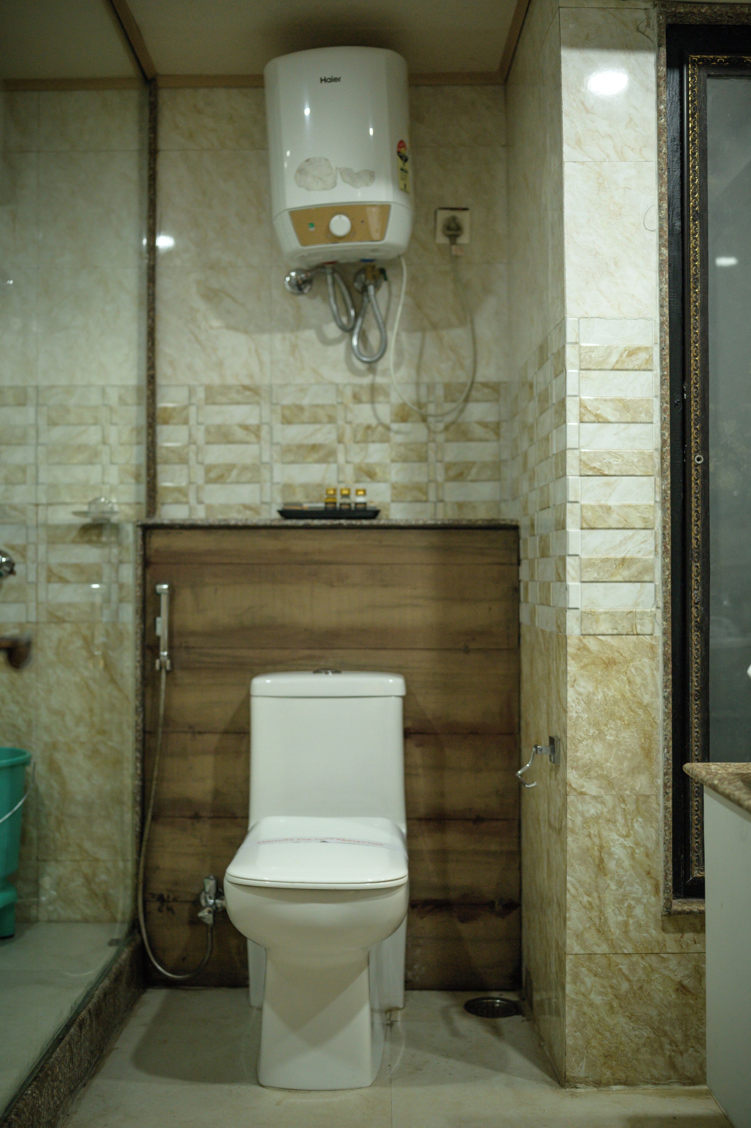 Un baño con inodoro, ducha y calefacción integrada.