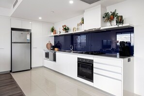 A modern kitchen with a built-in oven, a refrigerator, and a stove.