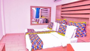 A bedroom with a bed, a mirror, and a wooden headboard.
