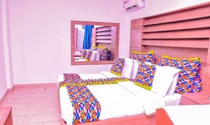 A bedroom with a bed, a mirror, and a wooden headboard.