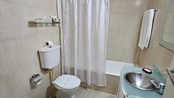 A bathroom with a toilet, bidet, and sink.