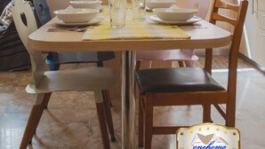 A dining area with a table set for four, a window above the sink, and a view of the outside. - Family Central in Kalamata (Kalamata)