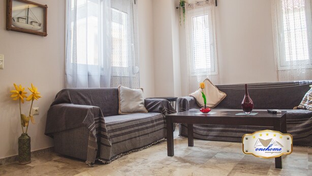 A living room with two sofas, a coffee table, and a vase with flowers. - Family Central in Kalamata (Kalamata)