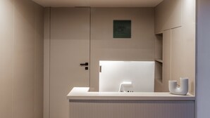 Un baño moderno y minimalista con lavamanos integrado, toallero y espejo.