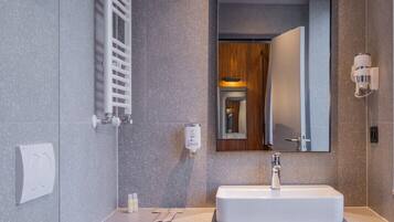 A modern bathroom with a built-in sink, a toilet, and a towel rack.