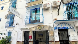 A building with a sign reading "MICAELA HOSTAL" and a stone facade. - Micaela Charming Hostal (Torremolinos)