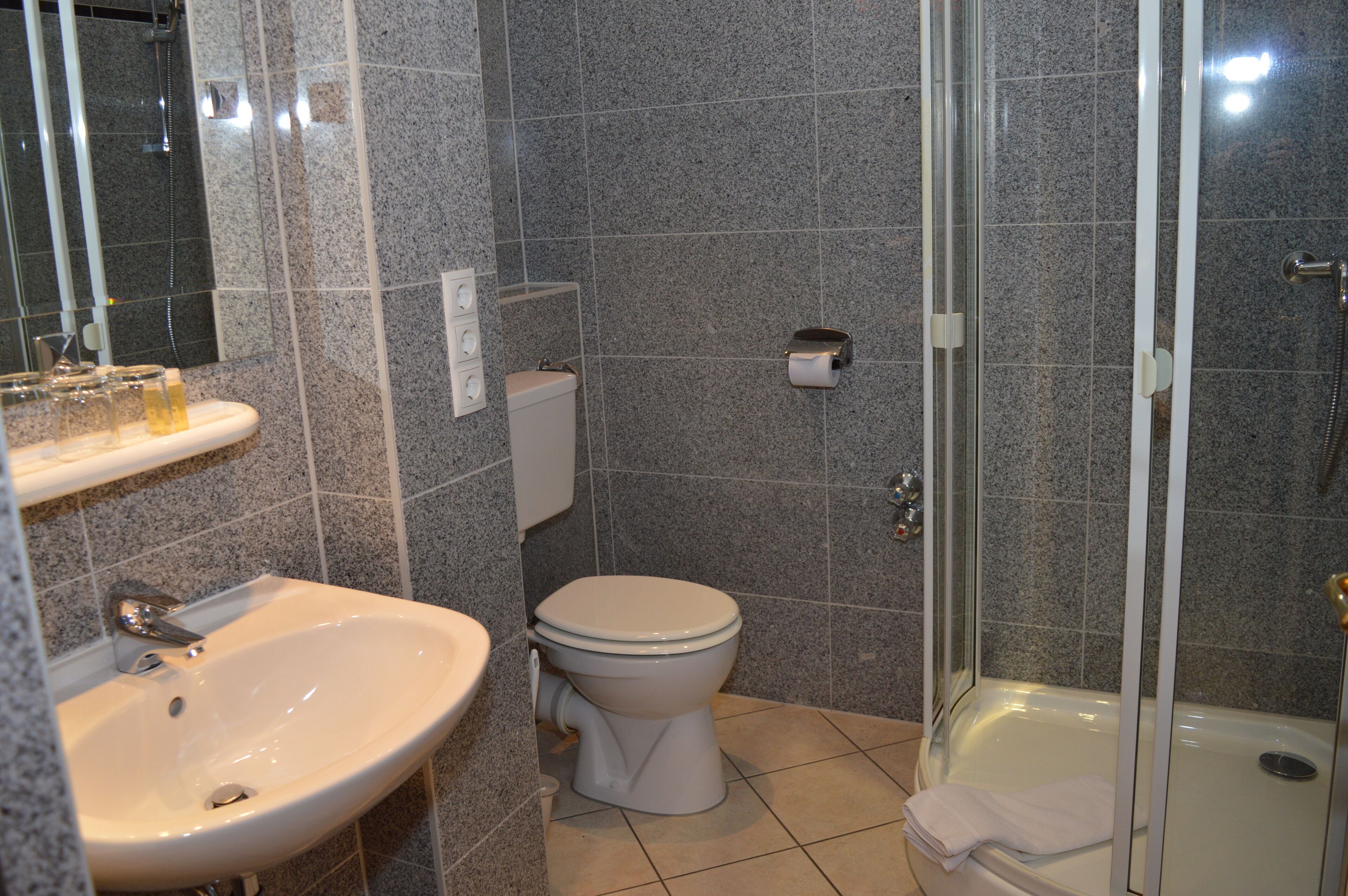 Un baño con lavamanos, inodoro y ducha.