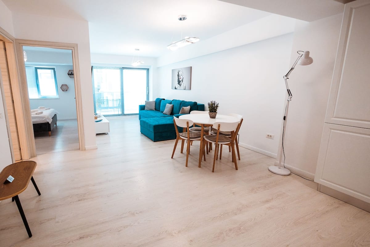 A modern living space with a dining area, a sofa, and a chair.
