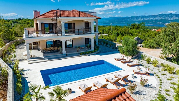 Ein zweistöckiges Haus mit Swimmingpool, Außenbereich und Bergblick.
